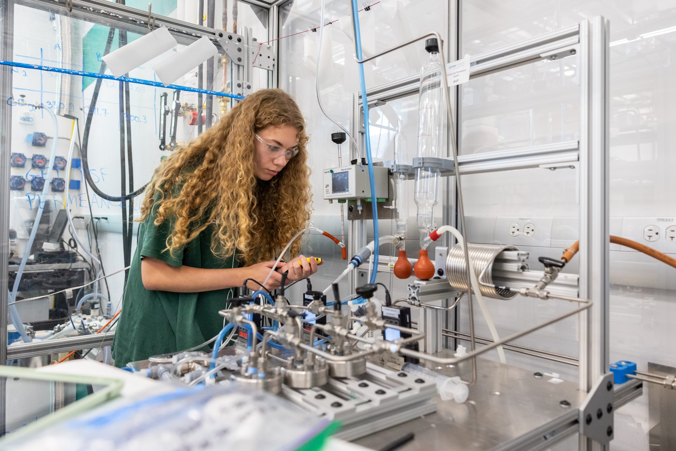 female student in lab in front of lab equipment conducting research